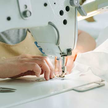 close up of woman using an industrial sewing machine